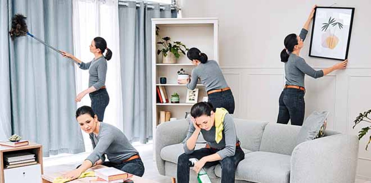 2191561413 Woman multitasking, busy and cleaning the living room and doing all the chores. Tired superwoman, frustrated with time management and overworked on housework. Spring cleaning before family gets home