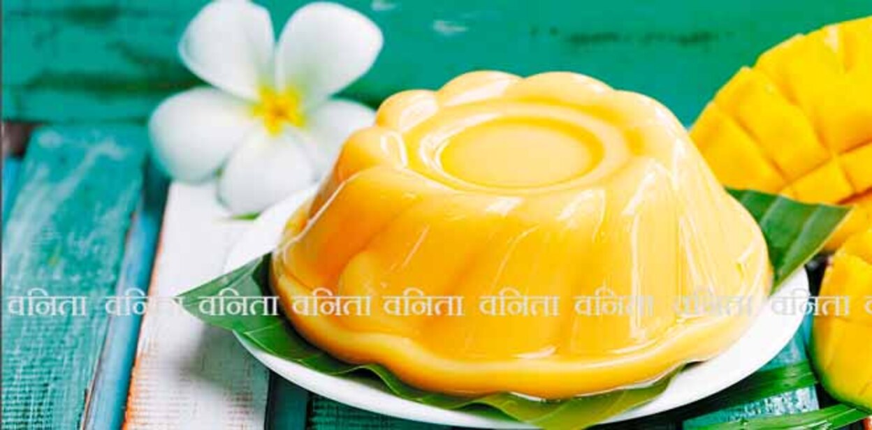 Mango pudding, jelly on white plate with palm leaf. Colorful wooden background.