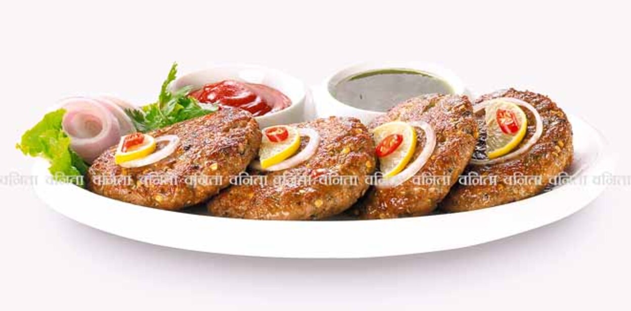 shami-kebab Spicy Pakistan Chapli Kebabs with fresh vegetables close up in the plate on the table.