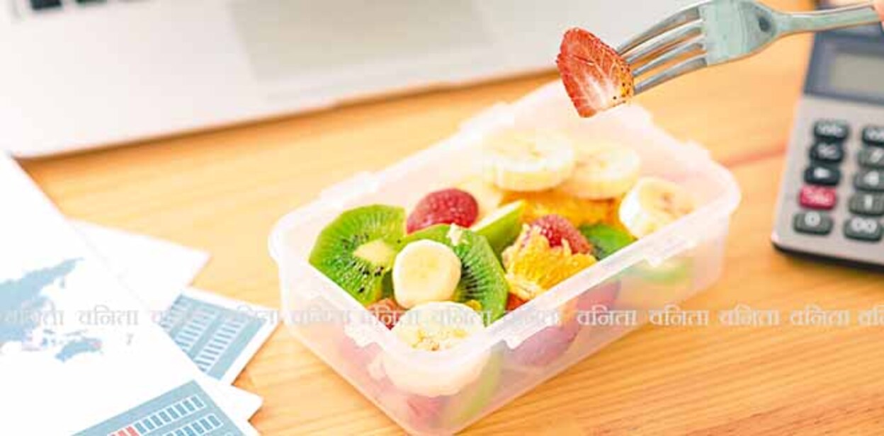 209108224 Plastic container with fruit salad and a fork on the desk, selective focus