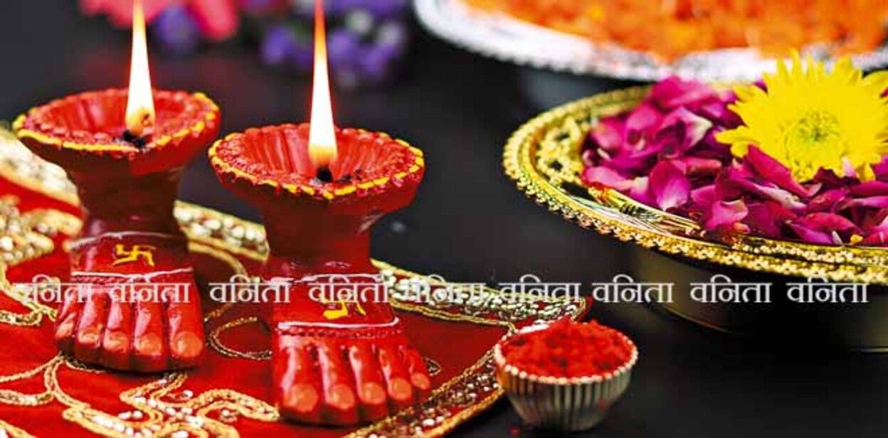 2064902552 Clay Lamp Known As Diya, Deep, Diyo, Deepa Or Deepam WIth Goddess Feet Lakshmi Charan Illuminating On Red Cloth Asan With Roli Sindoor Flowers And Bokeh Effect. Shubh Deepawali And Laxmi Pooja Theme