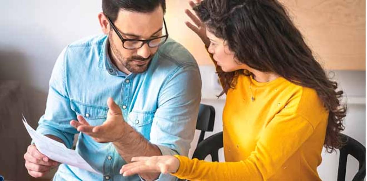 Husband and wife fighting over money and expenses, couple arguing over bills stock photo