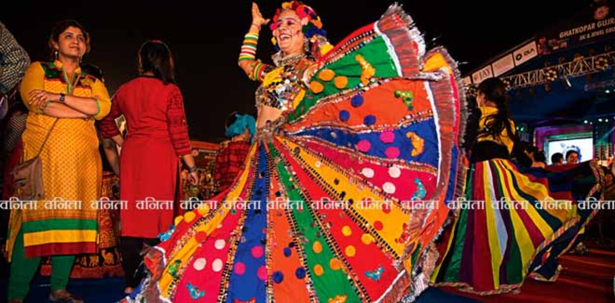 Mumbai, India - October 16, 2015 - Female dancers  in traditional colorful Indian costume on the floor among crowd during Navratri (nine-day) dance Festival