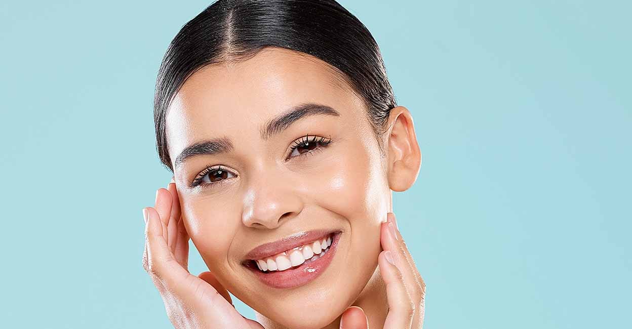 Smile, portrait and woman for skincare in studio with beauty, cosmetics and facial treatment at spa for healthy skin. Happy, hand and natural, glow and shine from dermatology care on blue background