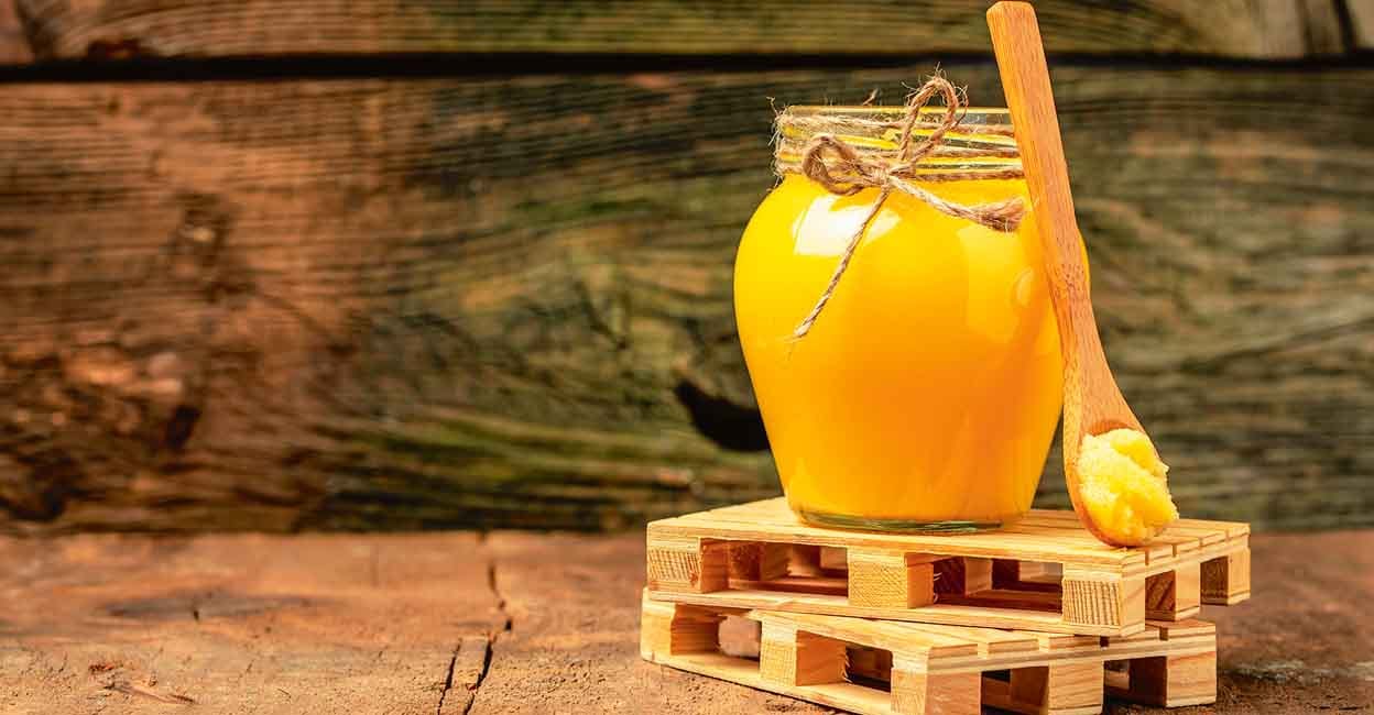 ghee oil. Ghee or clarified butter in jar on a wooden background. banner, menu, recipe place for text.