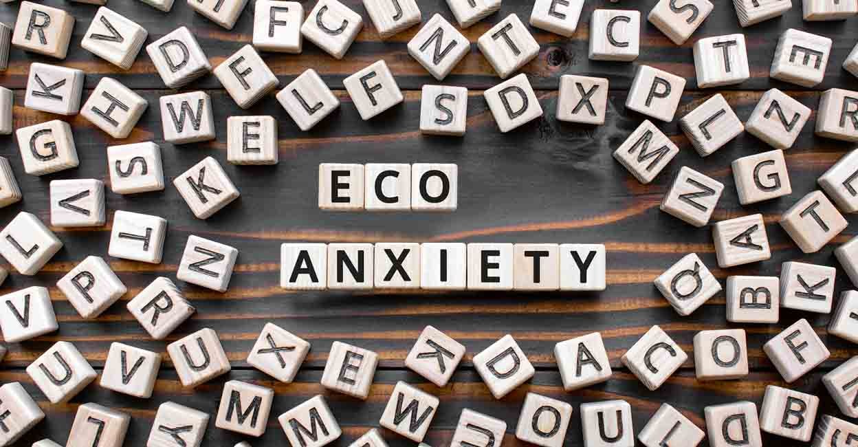 Eco-anxiety phrase from wooden blocks with letters, ecological disasters natural environment pollution and climate change, eco anxiety concept, random letters around, top view wooden background