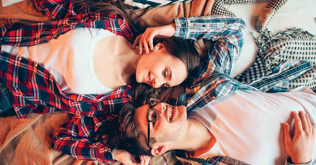 Love couple in clothes embrace on couch, top view