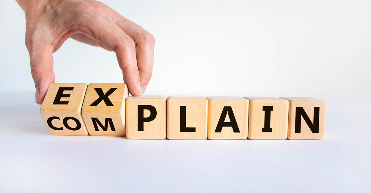 Explain vs complain symbol. Male hand flips wooden cubes and changes the word 'complain' to 'explain'. Beautiful white background, copy space. Business and explain vs complain concept.