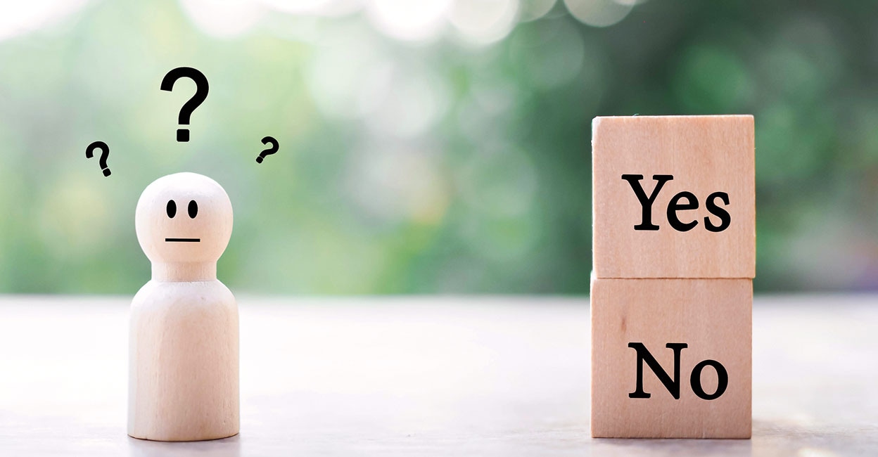 Wooden human figure with question marks. The concept of choice Yes or No. Choice hesitate, making decision