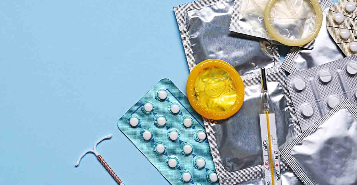 2402143993 Contraceptive pills, condoms, intrauterine device and thermometer on light blue background, flat lay with space for text. Different birth control methods